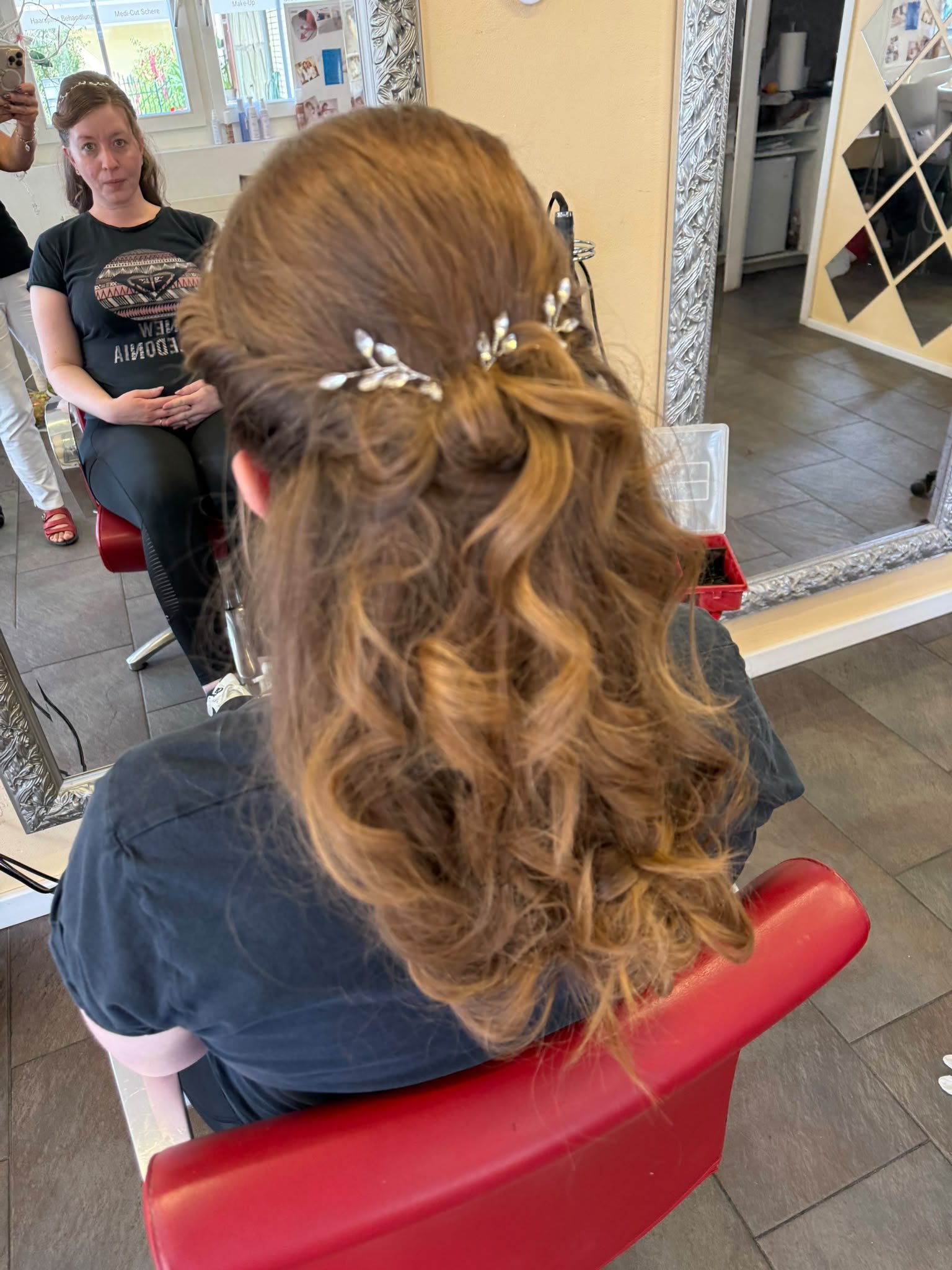 Halboffene Lockenfrisur mit Haarschmuck von der Seite
